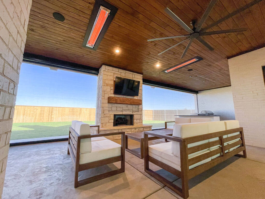 Enclosed porch with Outdoor kitchen with stone counters and built-in grill in Lubbock, TX backyard sport court West Texas