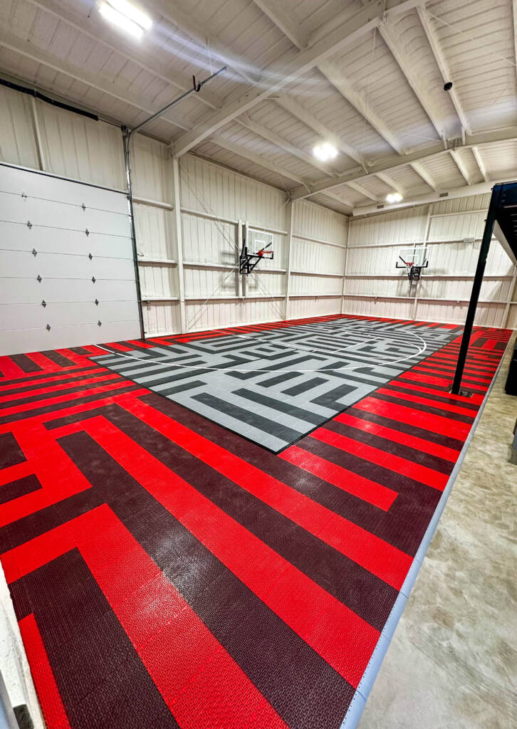Indoor basketball court with custom red, gray, and black SnapSports surface installed by Teko Courts & Outdoor Living in West Texas.